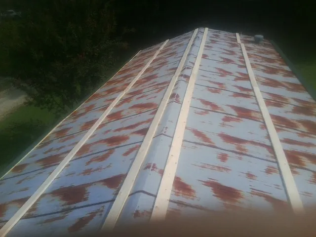Rusted metal roof panels with new wood purlins before replacement — Storm Damage Roof Repair in Omro by Roofing Brothers