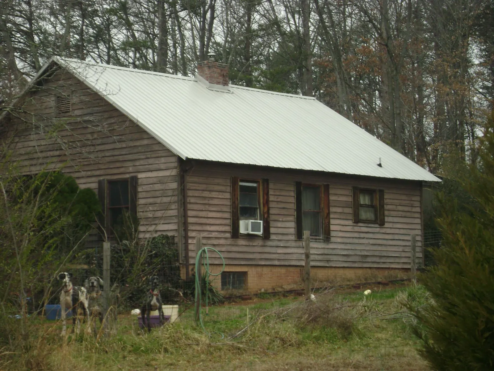 White metal roof on an old wood sided farmhouse, from a Metal Roof Installation job in Omro